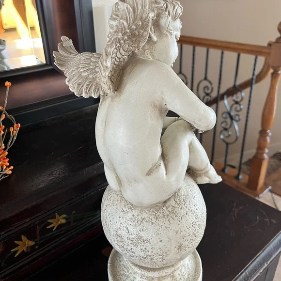 Resin angel statue on a ball 14 1/2 tall 8” wide cream colored